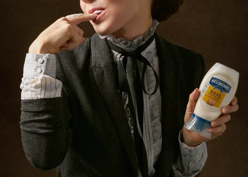 woman in black coat holding product bottle